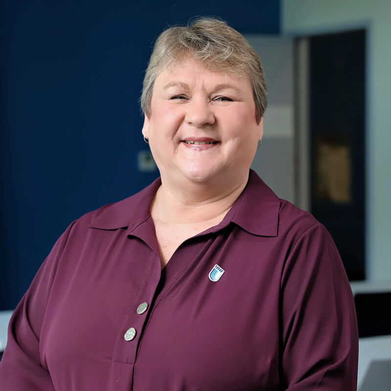 A portrait of Janine Gray smiling