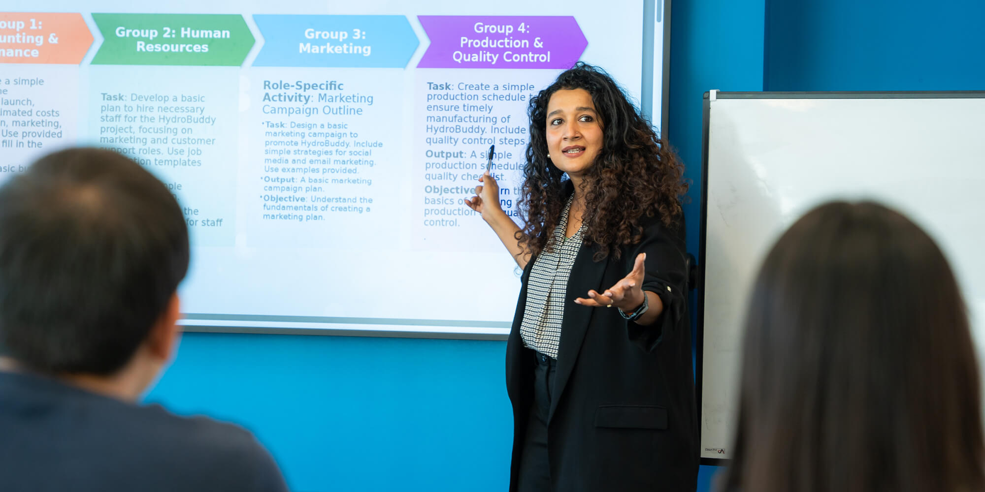 A woman presents to an audience, engaging them with her speech and visual aids in a professional setting