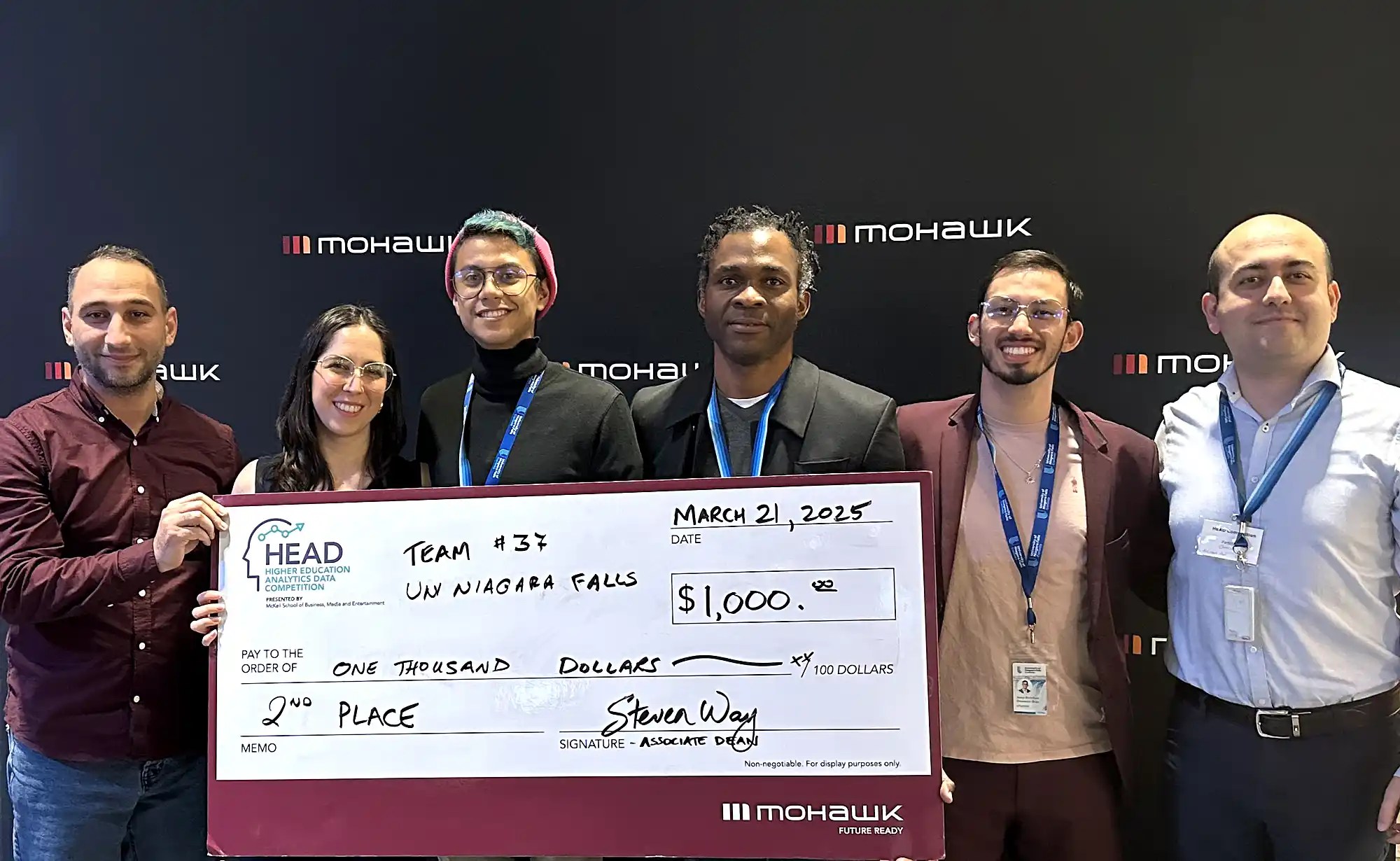 students holding a winning cheque