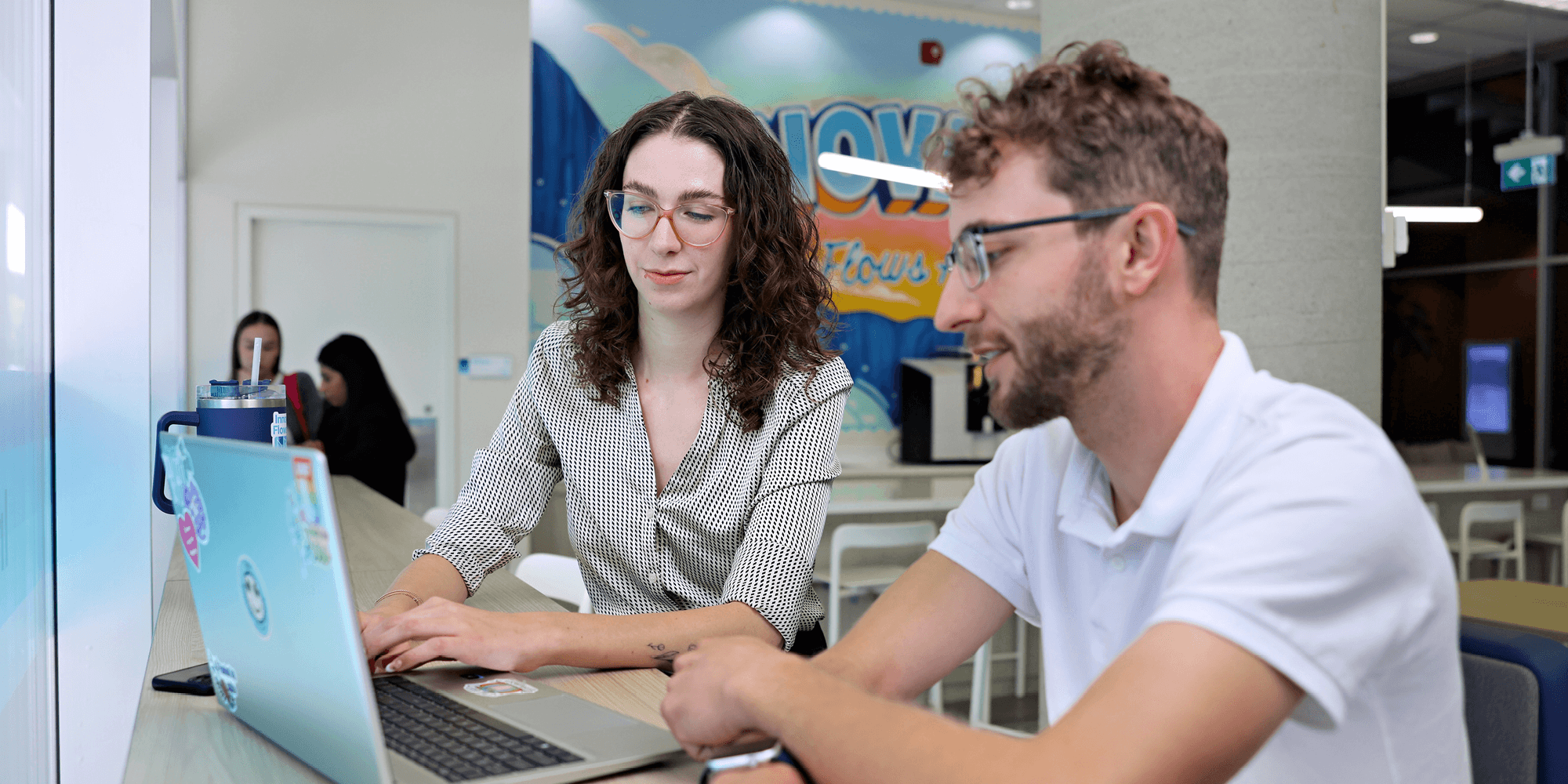 Two students looking at a laptop inside UNF campus